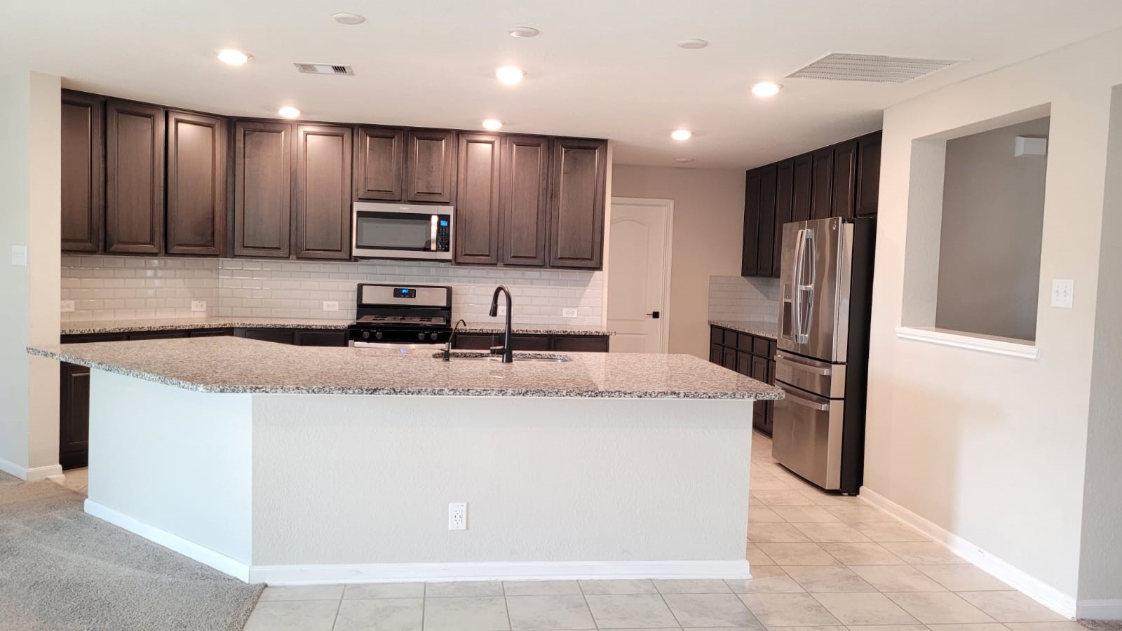 5704 Bluebonnet Lane Rosenberg, TX 77469 - Photo 7 of 34 a kitchen with stainless steel appliances granite countertop a sink and a refrigerator