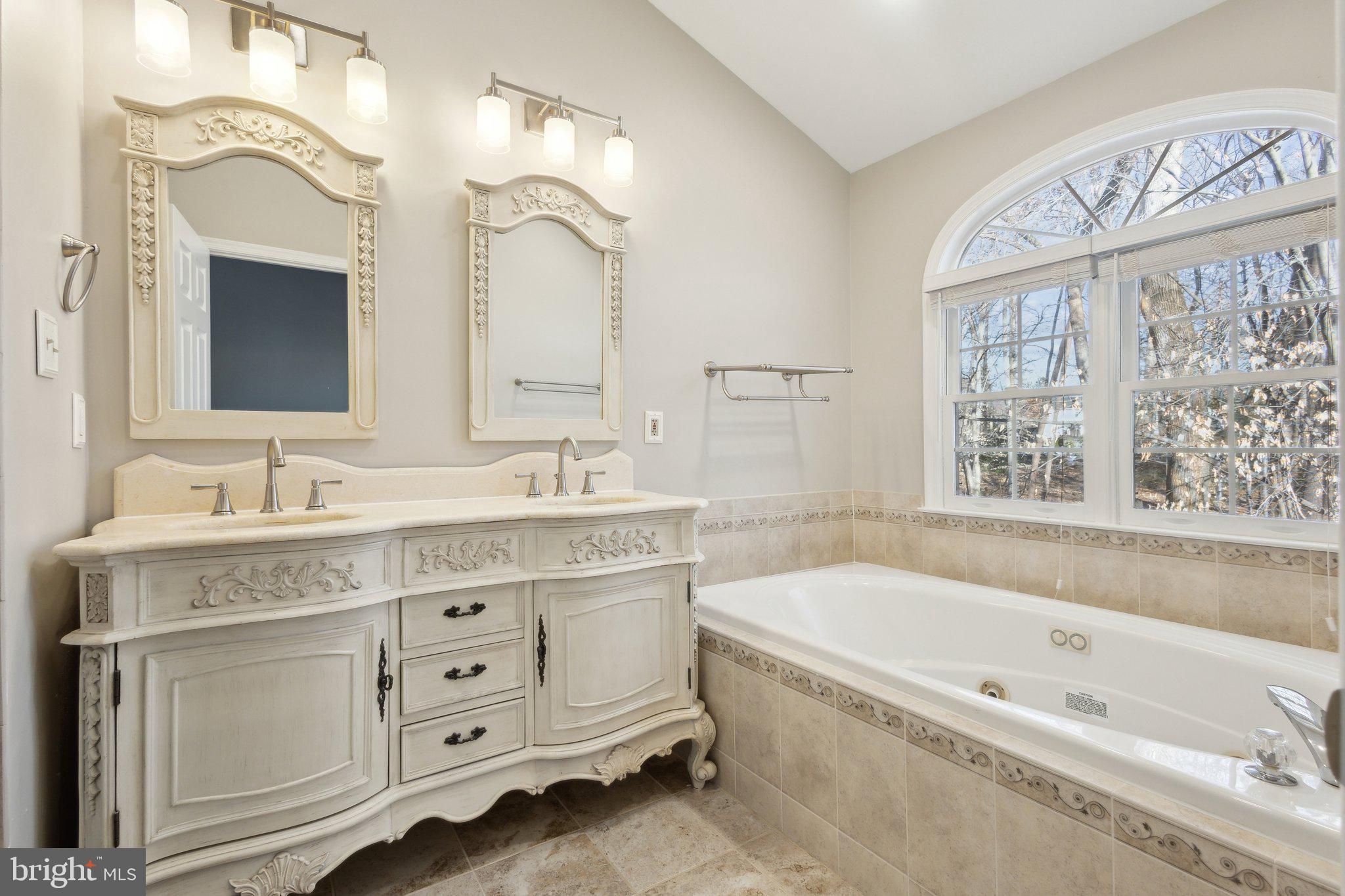 8802 Eagle Rock Lane Springfield, VA 22153 - Photo 11 of 18 a bathroom with a granite countertop bathtub sink double vanity and a window
