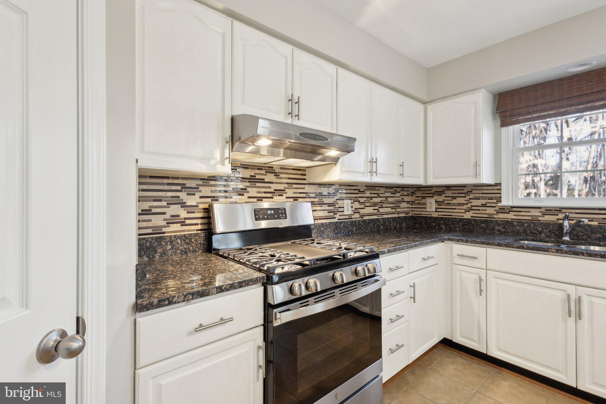 8802 Eagle Rock Lane Springfield, VA 22153 - Photo 7 of 18 a kitchen with granite countertop a stove sink and cabinets