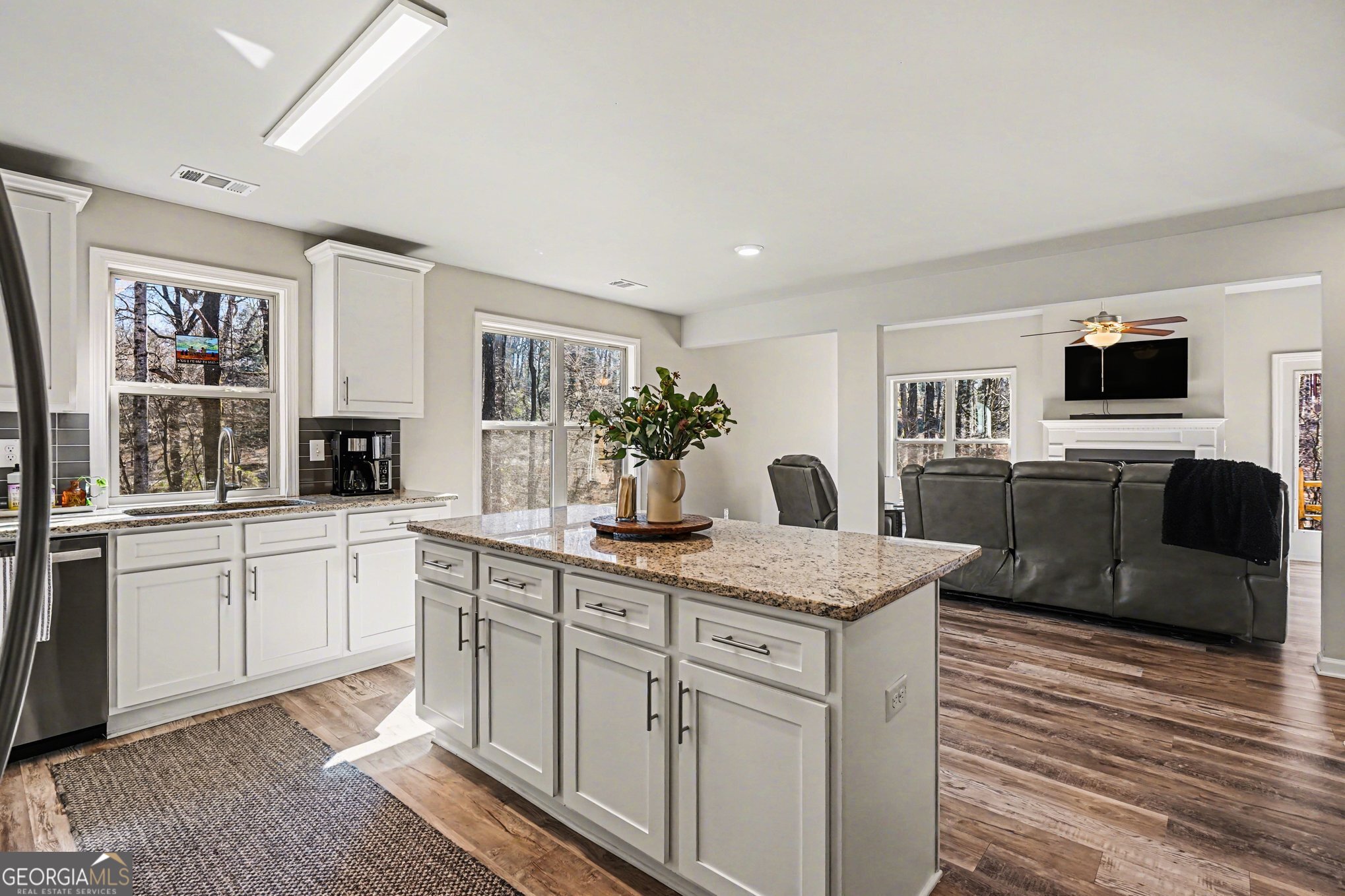 994 Lakeview Drive Commerce, GA 30529 - Photo 15 of 42 a kitchen with stainless steel appliances granite countertop a sink dishwasher and white cabinets with wooden floor