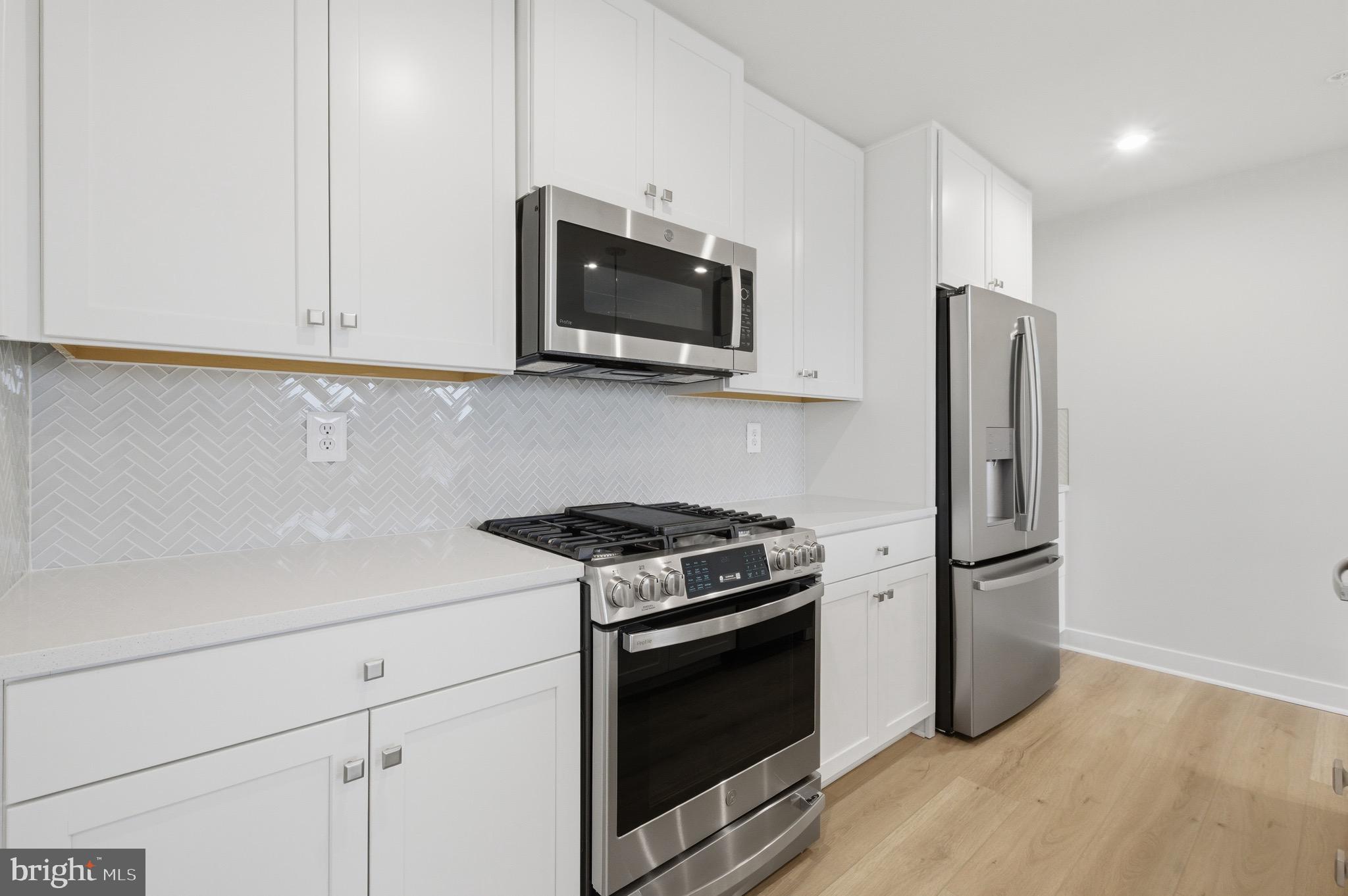 14421 Albemarle Point Place Chantilly, VA 20151 - Photo 10 of 25 a kitchen with stainless steel appliances white cabinets and a stove top oven