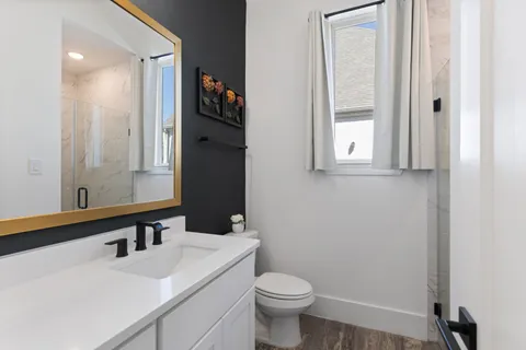 a bathroom with a sink a toilet and mirror