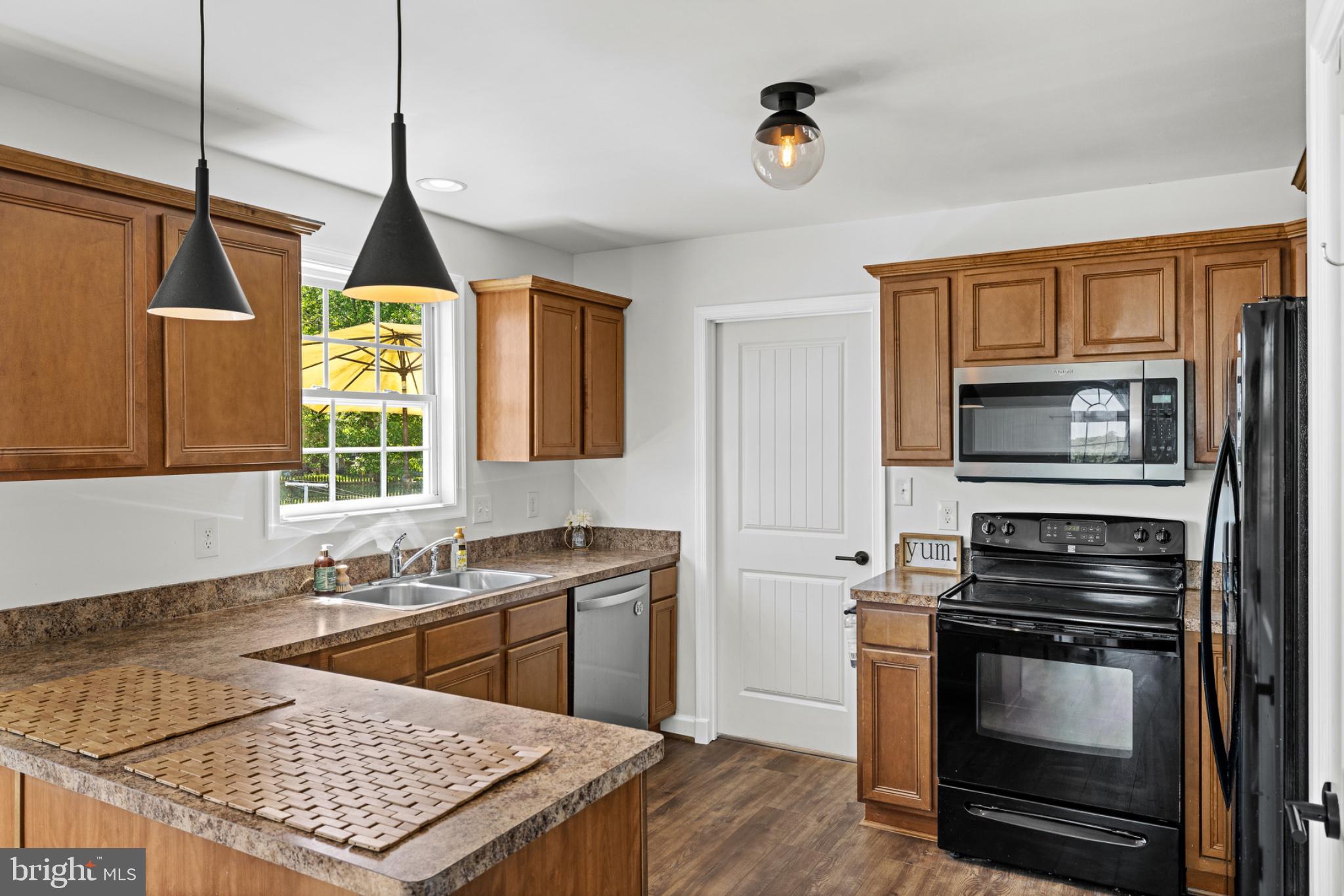 1523 Bowie Road Colonial Beach, VA 22443 - Photo 12 of 34 a kitchen with a stove a sink and a wooden floor