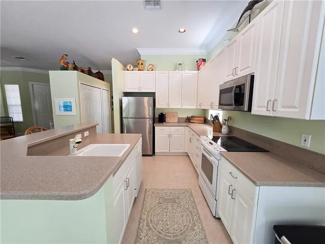 a large kitchen with a sink and refrigerator