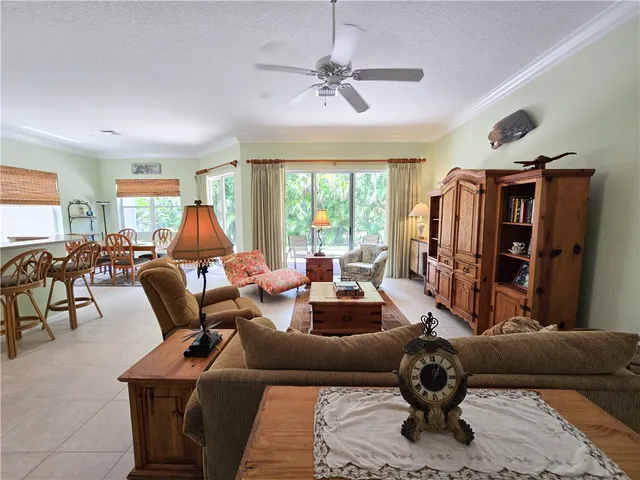 a living room with furniture ceiling fan and a window