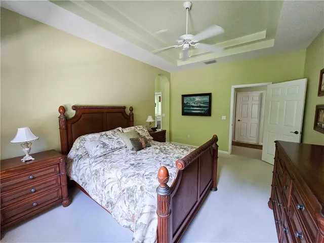 a bedroom with a bed and a flat tv screen on dresser