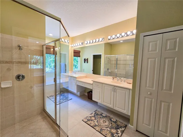 a large bathroom with a glass shower door and a bathtub