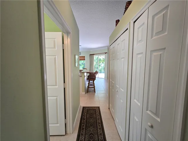 a view of a hallway with wooden floor and a bathroom