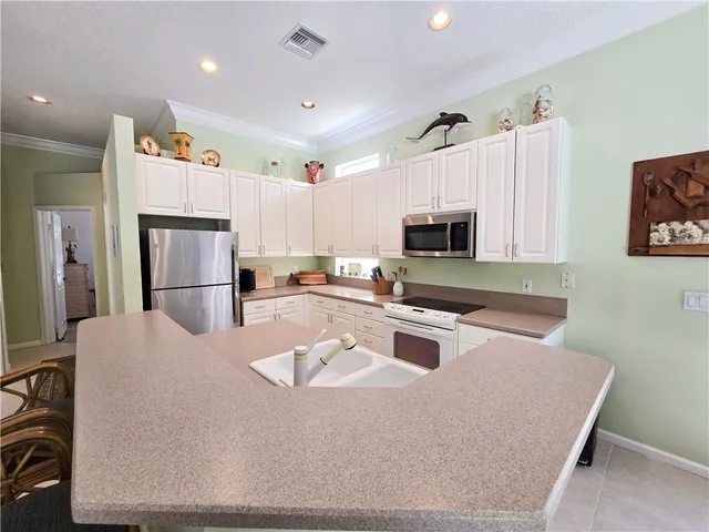 a kitchen with stainless steel appliances granite countertop a refrigerator stove microwave and sink
