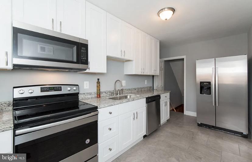 1224 Winston Avenue Baltimore, MD 21239 - Photo 11 of 26 a kitchen with stainless steel appliances a stove microwave and sink