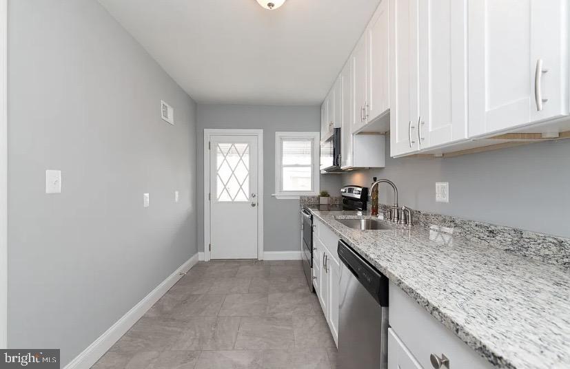 1224 Winston Avenue Baltimore, MD 21239 - Photo 12 of 26 a kitchen with granite countertop a sink a stove and cabinets