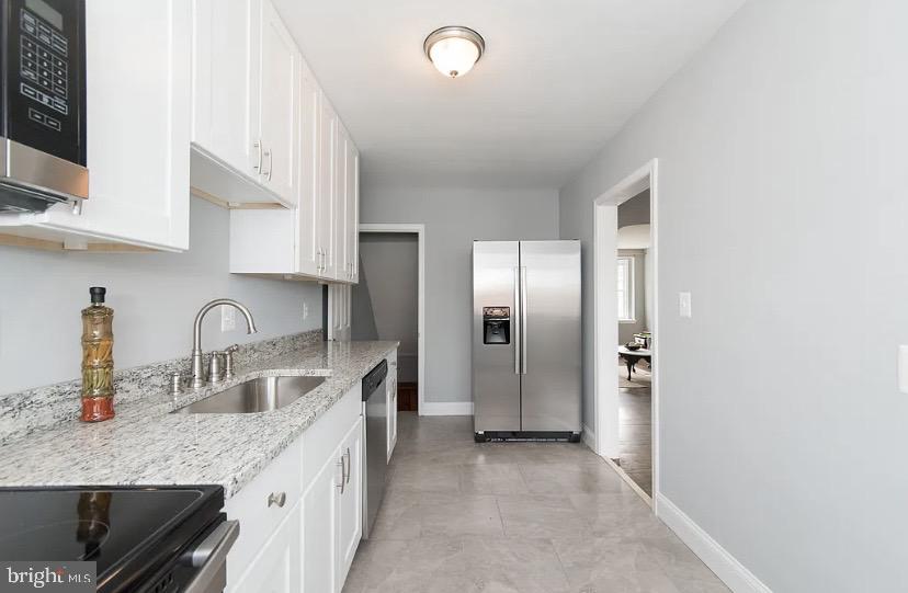 1224 Winston Avenue Baltimore, MD 21239 - Photo 14 of 26 a kitchen with stainless steel appliances granite countertop a sink stove and refrigerator