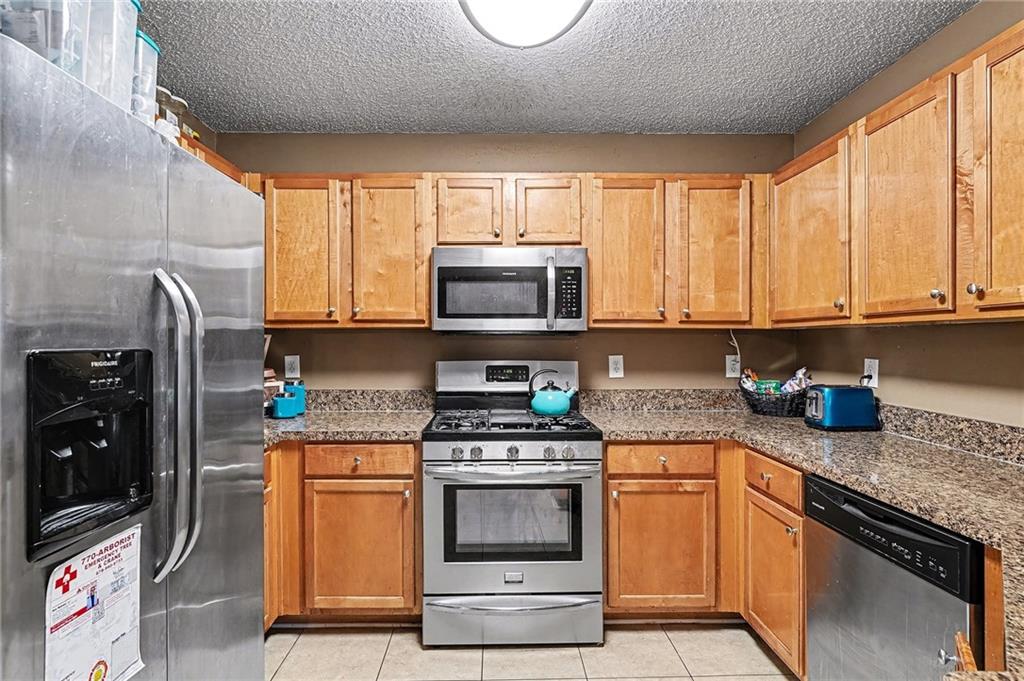 11811 Registry Boulevard Hampton, GA 30228 - Photo 11 of 33 a kitchen with stainless steel appliances granite countertop a stove a sink and a microwave