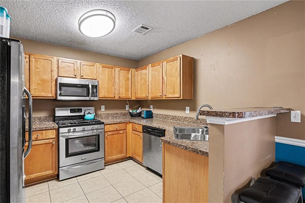 11811 Registry Boulevard Hampton, GA 30228 - Photo 12 of 33 a kitchen with a stove a sink and a microwave
