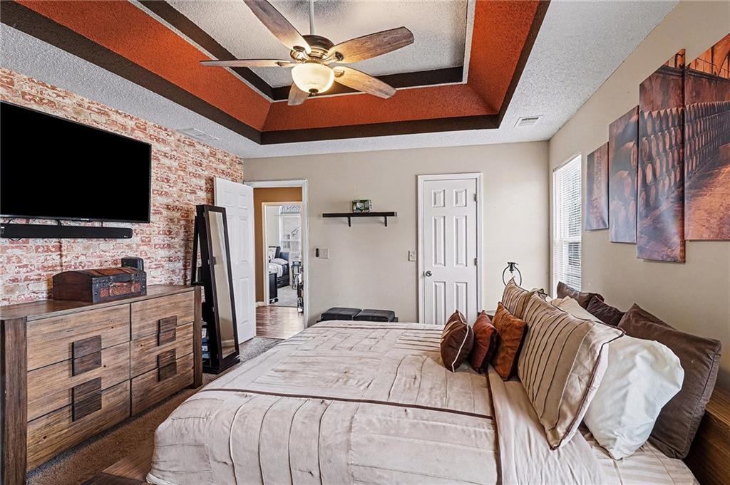 11811 Registry Boulevard Hampton, GA 30228 - Photo 23 of 33 a bedroom with a bed and a flat screen tv