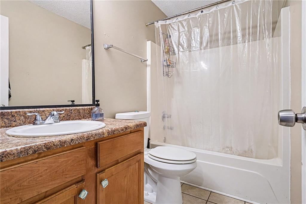 11811 Registry Boulevard Hampton, GA 30228 - Photo 28 of 33 a bathroom with a granite countertop sink a toilet and shower