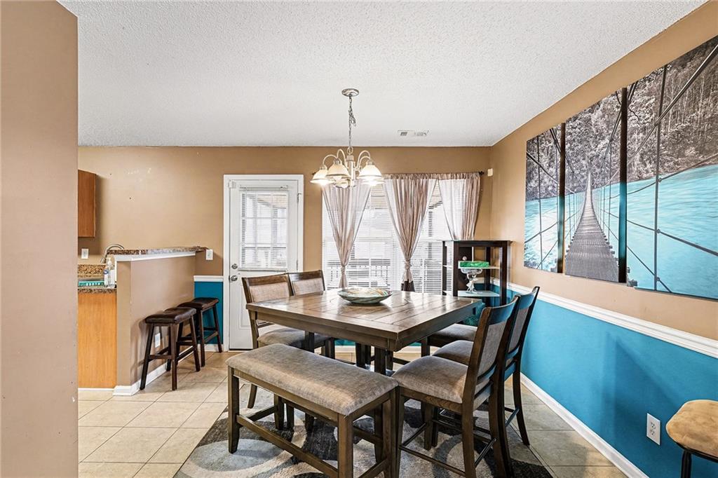 11811 Registry Boulevard Hampton, GA 30228 - Photo 9 of 33 a dining room with furniture a chandelier and wooden floor