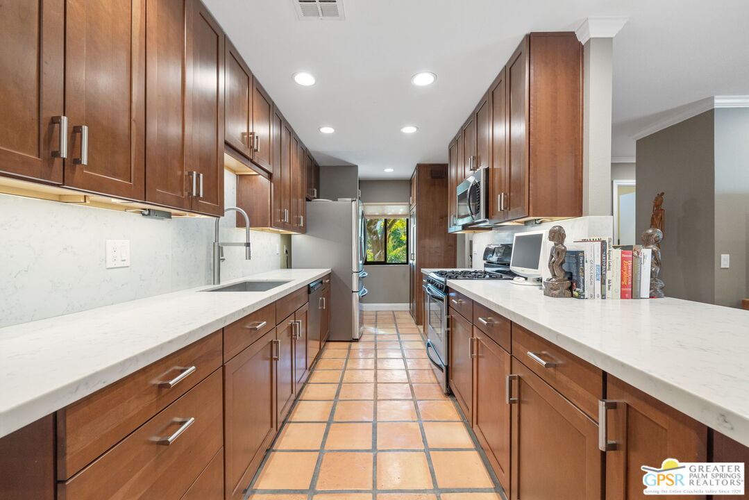 1115 East Alejo Road Palm Springs, CA 92262 - Photo 20 of 40 a large kitchen with stainless steel appliances lots of counter space and a sink