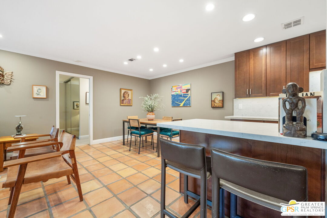 1115 East Alejo Road Palm Springs, CA 92262 - Photo 24 of 40 a living room with a dining table and a sink with chair