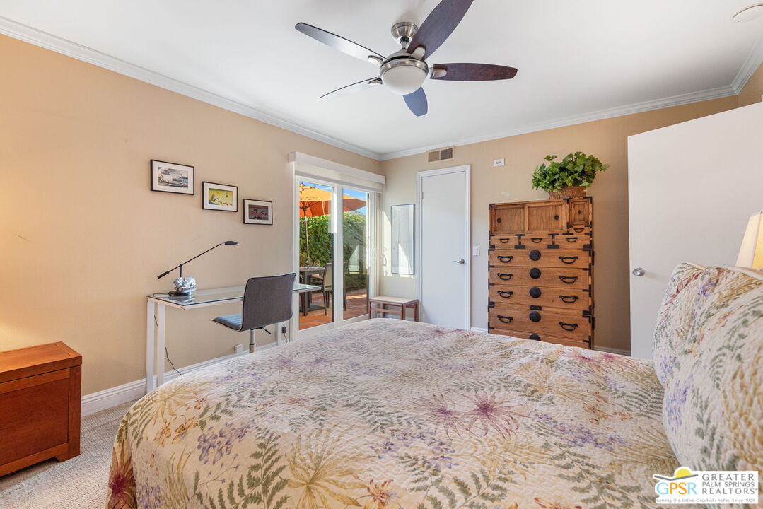 1115 East Alejo Road Palm Springs, CA 92262 - Photo 32 of 40 a bedroom with a large bed and a chandelier