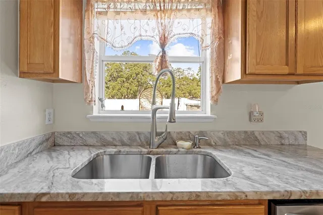 a kitchen with stainless steel appliances granite countertop a refrigerator a stove and a sink