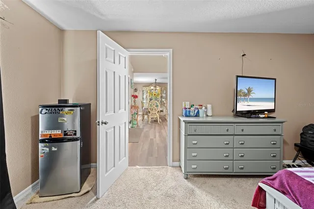 a bedroom with a bed and a lamp on dresser