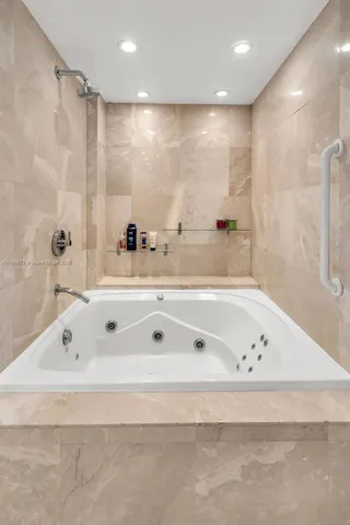 a bathroom with a tub a sink and a shower