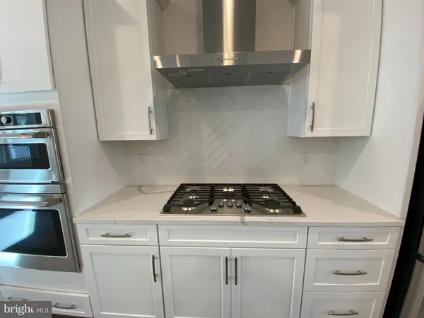 a kitchen with white cabinets and black appliances