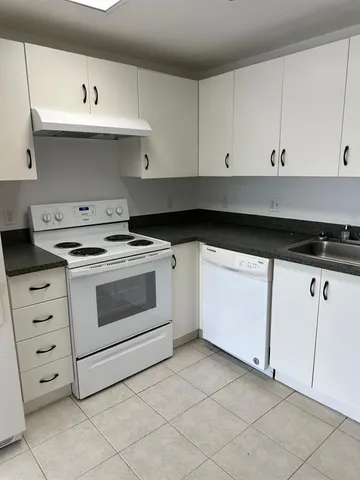 a kitchen with white cabinets and white appliances