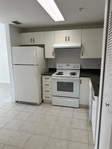 a kitchen with a stove a refrigerator and a cabinets