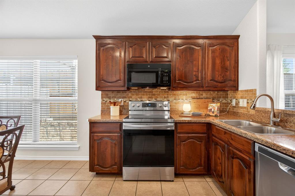 5069 Britton Ridge Lane Fort Worth, TX 76179 - Photo 10 of 32 Behind the photographer is another bank of cabinetry plus a breakfast bar.