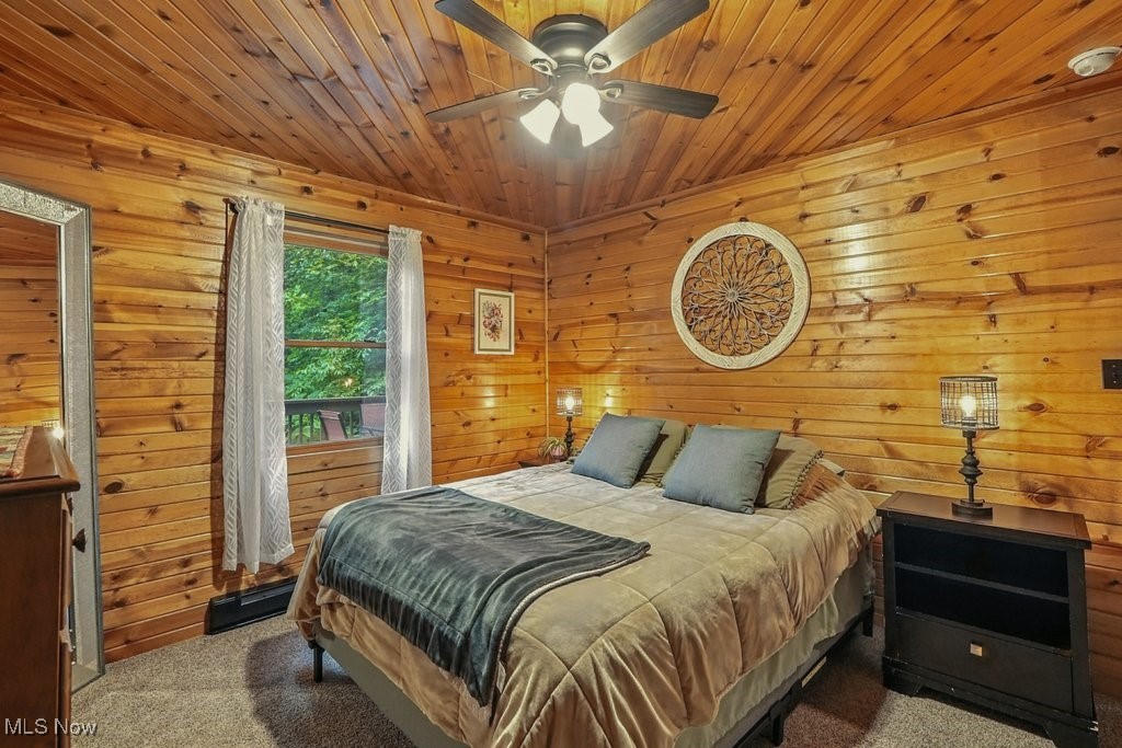 6711 Booth Road Ravenna, OH 44266 - Photo 20 of 50 Bedroom featuring carpet flooring, wooden walls, a ceiling fan, and wooden ceiling