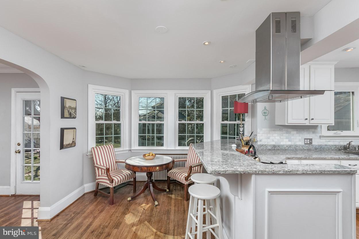 513 Wilton Road Baltimore, MD 21286 - Photo 7 of 30 a kitchen with a sink dishwasher a stove and a dining table with wooden floor
