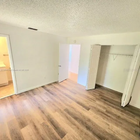 an empty room with wooden floor and door