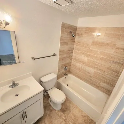 a bathroom with a bathtub shower sink vanity and toilet