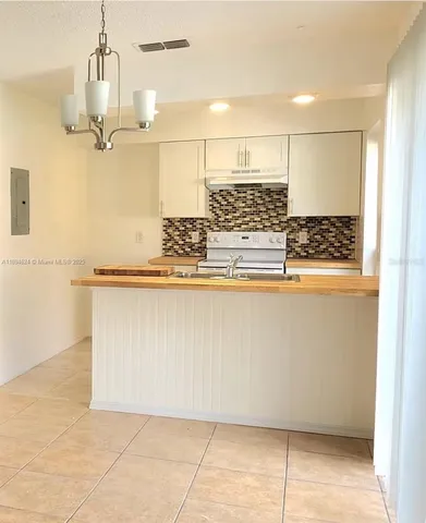 a view of kitchen with granite countertop a sink and a stove