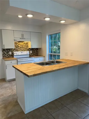 a view of kitchen with stainless steel appliances granite countertop a sink and a stove