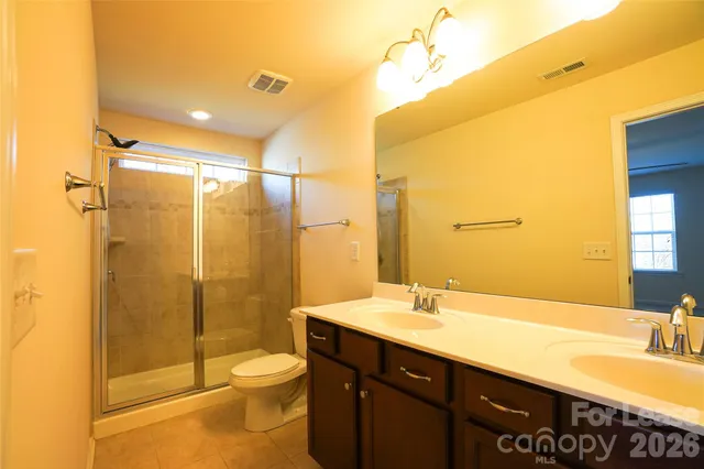 a bathroom with a double vanity sink toilet and shower