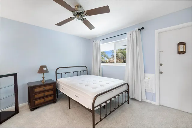 a bedroom with a bed table and a window