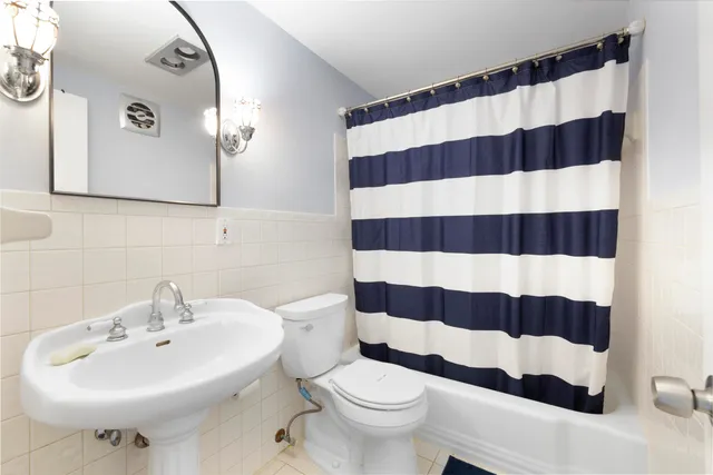 a bathroom with a sink a toilet and shower curtain