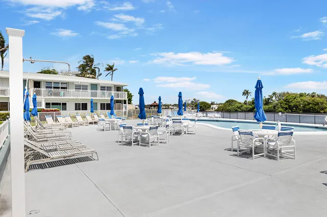 a view of a patio with dining table and chairs with a small yard