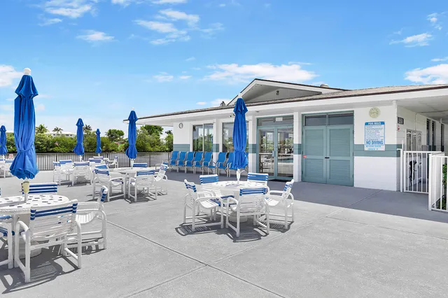 a view of a patio with dining table and chairs with a small yard