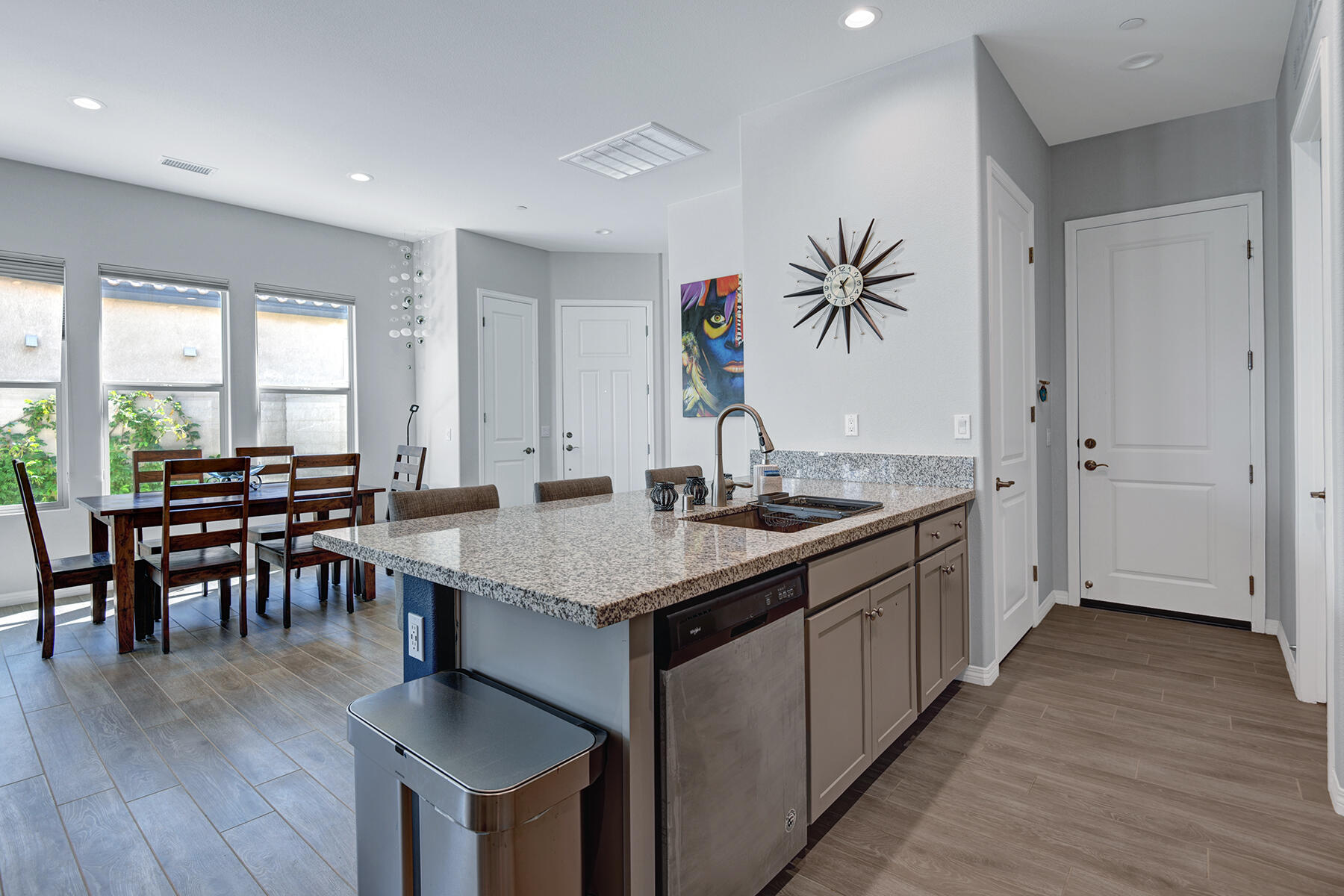 58 Claret Road Rancho Mirage, CA 92270 - Photo 6 of 33 a kitchen with granite countertop a table chairs a sink dishwasher stove and wooden floor