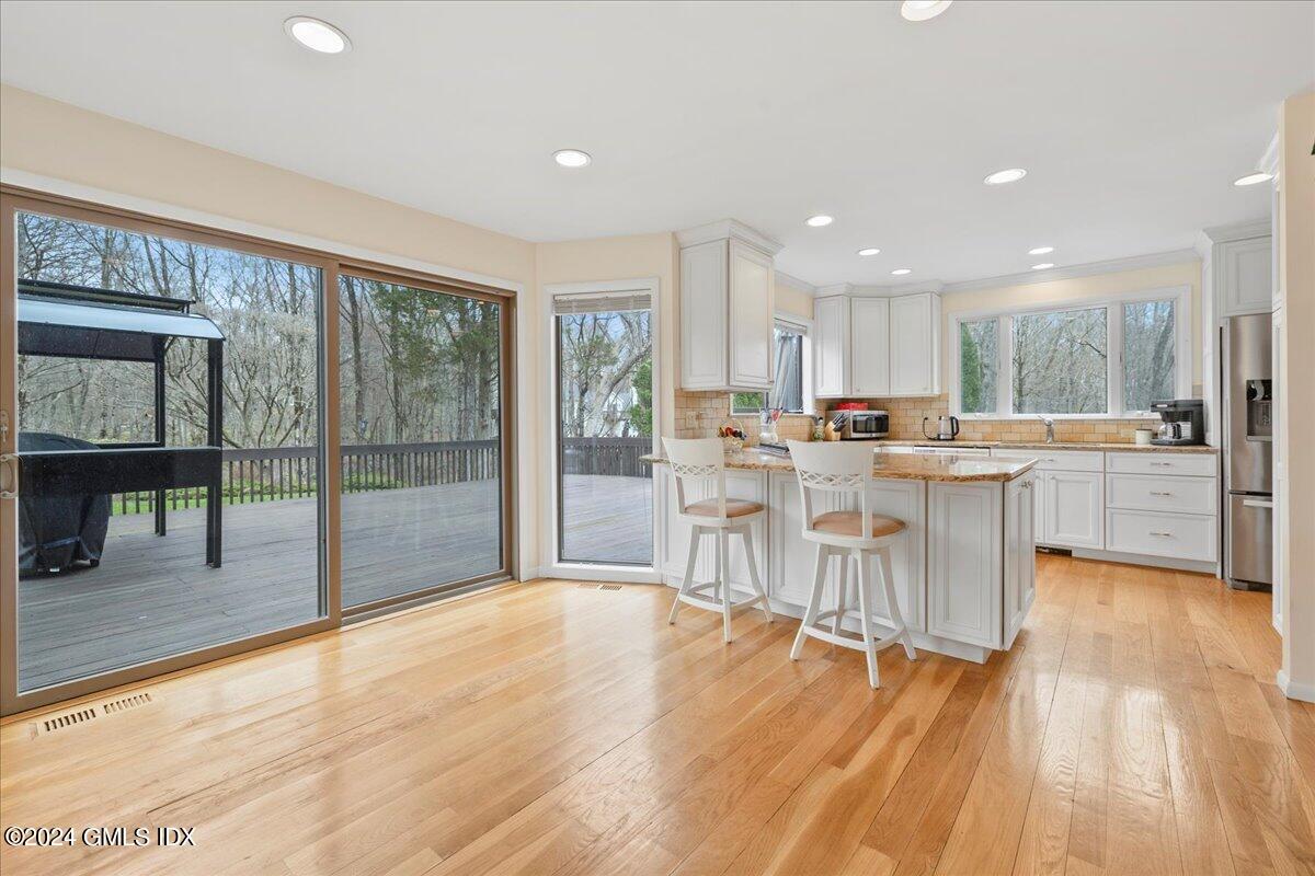 693 Den Road Stamford, CT 06903 - Photo 11 of 32 a room with stainless steel appliances kitchen island granite countertop a refrigerator a sink a stove and a wooden cabinets with wooden floor