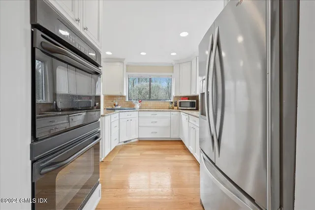 a kitchen with a refrigerator a sink and cabinets