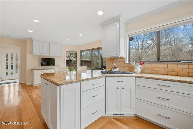 a kitchen with granite countertop a sink and cabinets