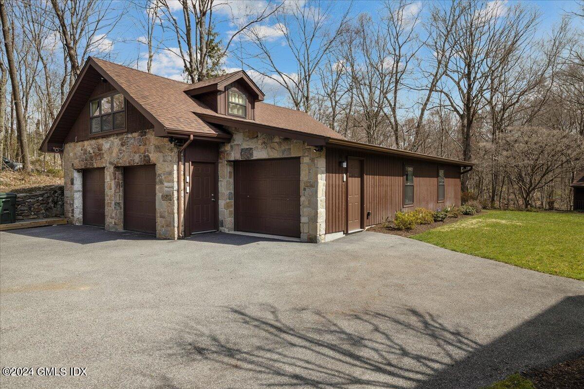 693 Den Road Stamford, CT 06903 - Photo 20 of 32 a front view of a house with a yard and garage