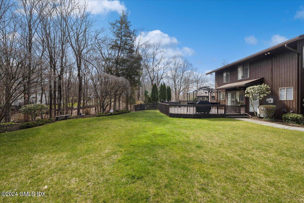 693 Den Road Stamford, CT 06903 - Photo 22 of 32 a view of a house with a big yard and large trees