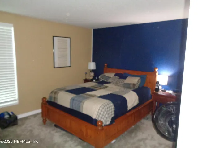 a bed sitting in a bedroom next to a window