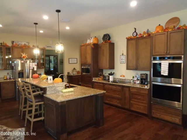 a kitchen with granite countertop a sink cabinets and stainless steel appliances